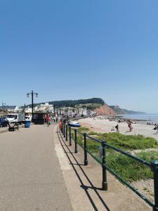 a beach with a fence and people on the beach at DRYSTONES in Sidmouth