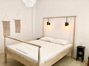 ein Bett mit einem Holzrahmen in einem Zimmer in der Unterkunft Veletas Apartments in Adamas