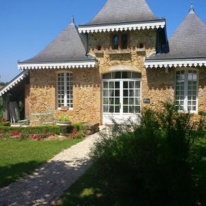 ceglany dom z białymi oknami i dziedzińcem w obiekcie Gîte MACHAXJU w mieście Hontanx