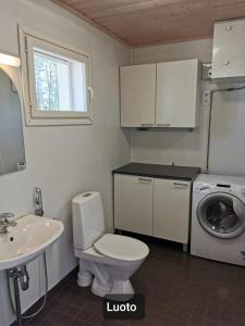 uma casa de banho com um WC, um lavatório e uma máquina de lavar roupa em Hamina Camping Pitkäthiekat em Hamina