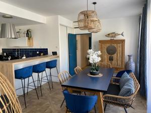 a kitchen and dining room with a blue table and chairs at Les Floralies Canebière in Marseille