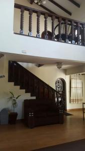 a living room with a black couch and stairs at Hotel el super 8 in Santa Cruz de la Sierra