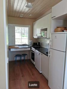 cocina con electrodomésticos blancos y nevera blanca en Hamina Camping Pitkäthiekat, en Hamina