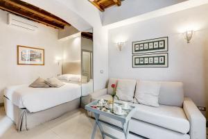 um quarto com uma cama, um sofá e uma mesa em Rome Frattina27 em Roma