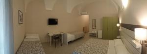 a room with two beds and a table in it at HOTEL MALIBU in Spotorno
