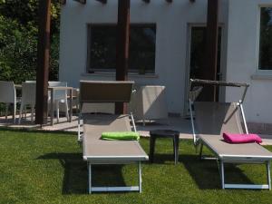 two lawn chairs with colorful cushions sitting on the grass at Fair Garden in Bardolino