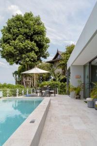 - une piscine avec une table et un parasol dans l'établissement Sasha Villa, à Choeng Mon Beach