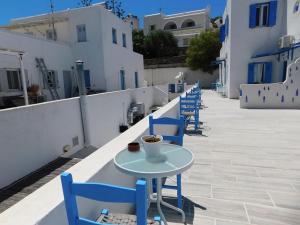 a row of blue chairs and a table with a cup of coffee at Yacht Front Studio - No 5 in Ios Chora