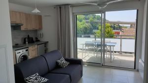 - un salon avec un canapé et une vue sur une terrasse dans l'établissement COTE VILLAGE, à Nice