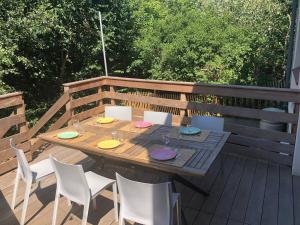 a wooden table and chairs on a wooden deck at Les Oyats in Camiers