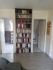una estantería llena de libros en la sala de estar en Chambres d'Hôtes Arques en Ciel, en Arques-la-Bataille