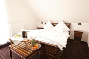 a bedroom with a bed with a bowl of fruit on a table at Althoff´s Landhotel in Ochtrup