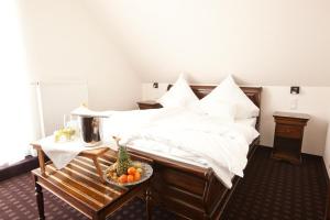 a bedroom with a bed with a bowl of fruit on a table at Althoff´s Landhotel in Ochtrup +5 photos
