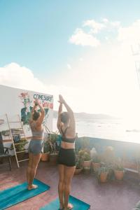 two women doing yoga on mats in front of the beach at Agüita House in Las Palmas de Gran Canaria