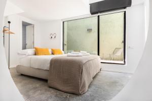 a bedroom with a bed and a large window at Slow Suites Maestranza in Seville