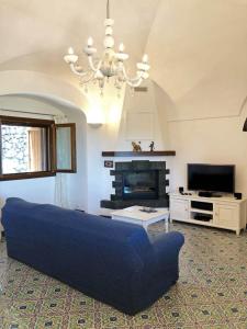 un soggiorno con divano blu e TV di Dammuso Sidori a Pantelleria