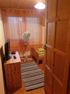 a room with a door and a desk and a fan at Violet Holiday’s House in Siófok