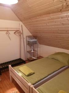 ein Schlafzimmer mit einem Bett und einer Holzdecke in der Unterkunft Violet Holiday’s House in Siófok