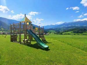 un parque infantil con un tobogán en un campo de césped en Residence Stefansdorf, en Brunico