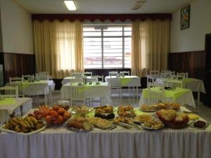 ein Tisch mit vielen verschiedenen Speisen darauf in der Unterkunft Hotel Avenida in Jacarèzinho