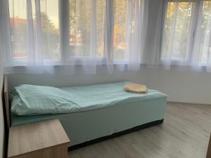 a bed sitting in a room with windows at Dom Wczasowy PORTOWA PRZYSTAŃ 150m od plaży in Mrzeżyno