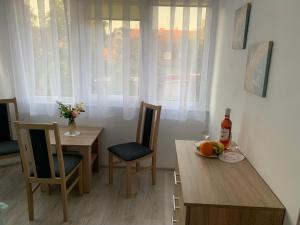 a dining room with a table and chairs with a bottle of wine at Dom Wczasowy PORTOWA PRZYSTAŃ 150m od plaży in Mrzeżyno