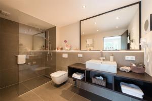a bathroom with a sink and a toilet and a shower at MUNTE - Wellnesshotel am Stadtwald in Bremen
