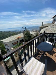 stół i krzesło na balkonie w obiekcie Arhontiko Theofilos w mieście Makrinítsa