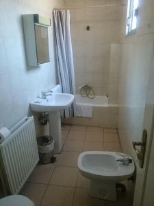 een badkamer met een wastafel, een toilet en een wastafel bij Hostal El Centro in Huesca