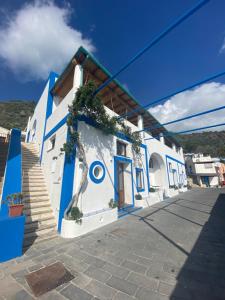 a blue and white building with stairs on a street at Da Nino sul mare in Filicudi