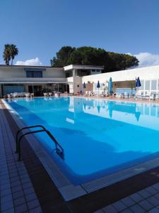 ベルヴェデーレ・マリッティモにあるBelvedere Hotel Clubの建物の前の青い水の大きなプール