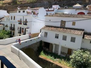 un groupe de bâtiments blancs sur une colline dans l'établissement Casa Cueva El Puente, à Setenil de las Bodegas