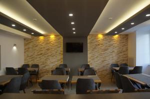 a waiting room with tables and chairs and a tv at Hotel Hecht in Feldkirch