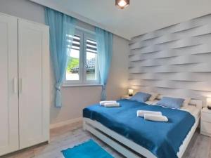 sypialnia z niebieskim łóżkiem i oknem w obiekcie Apartament Wiktoria w mieście Ustrzyki Dolne