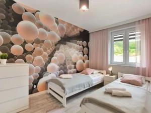 sypialnia z 2 łóżkami i ścianą z kulami w obiekcie Apartament Wiktoria w mieście Ustrzyki Dolne