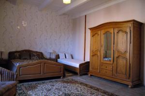 a bedroom with a bed and a dresser and a cabinet at Bed and Breakfast Dunroamin in Couture-dʼArgenson