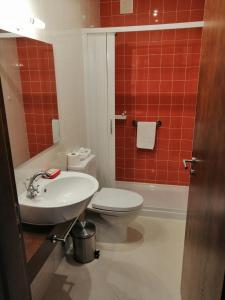 a bathroom with a white toilet and a sink at Sonetos do Tejo in Vila Nova da Barquinha