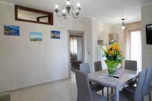 a dining room with a table with a vase of flowers at Il Vicoletto in Pimonte