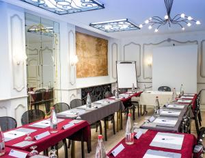 a meeting room with tables and chairs and a whiteboard at Kyriad Hotel Tours Centre in Tours