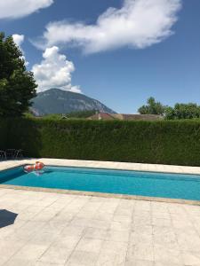a swimming pool in front of a hedge at Auberge de la Paillère in Lavours