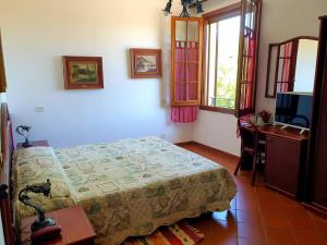 a bedroom with a bed and a desk and a television at Agriturismo La Cavaliera in Monteveglio