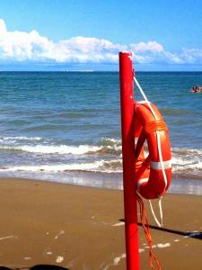 una boa di salvataggio arancione seduta sulla spiaggia di Villa Venice Movie a Lido di Venezia