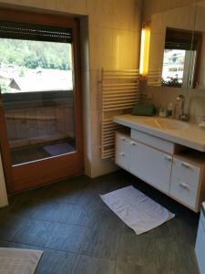 baño con lavabo, espejo y ventana en Appartements Told Elisabeth, en Fügen