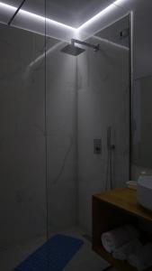 y baño con ducha acristalada y lavamanos. en H&M Hotel, en Vlorë