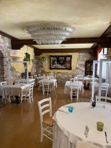 une salle à manger avec des tables et des chaises blanches dans l'établissement Ferrari, à Goro