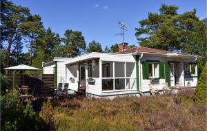 una pequeña casa blanca con un verde en Awesome Home In Hllviken With Kitchen, en Höllviken
