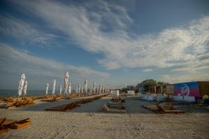 ママイア・ノルドにあるApartament Alexandraの浜辺のビーチチェアとパラソル