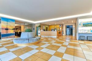 a lobby with a chair and a checkerboard floor at Hotel Baia Verde in Malcesine