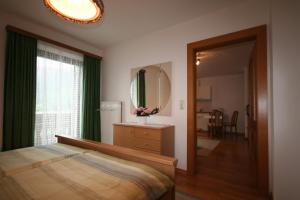a bedroom with a bed and a mirror and a window at Haus Ebner in Sankt Gilgen