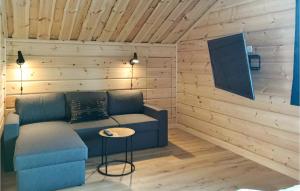 a living room with a blue couch and a table at Awesome Home In Vemdalen With 4 Bedrooms, Sauna And Wifi in Vemdalen